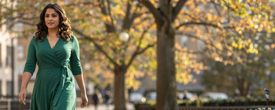 Female physician assistant walking through a sunny autumn park