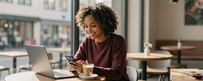 Female travel nurse laughing at a coffee shop while video calling
