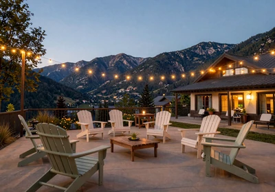 Luxury mountain resort patio at dusk with warm lighting