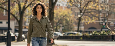 Mixed ethnicity physical therapist walking through a sunlit autumn park