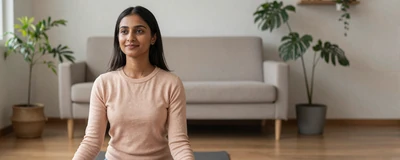 Female occupational therapist practicing yoga in a bright living room with plants